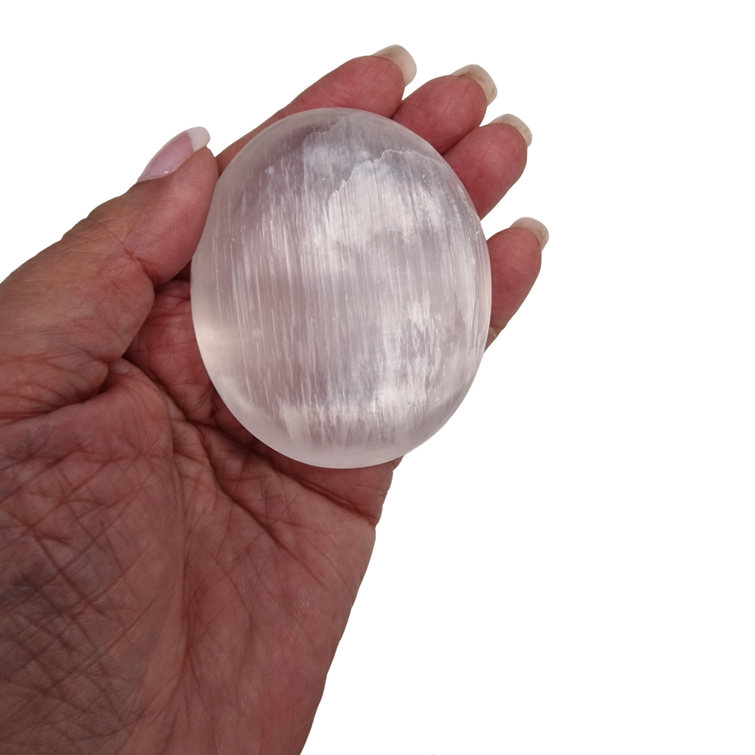 Selenite Palm Stone 70 mm shown on hand for scale.