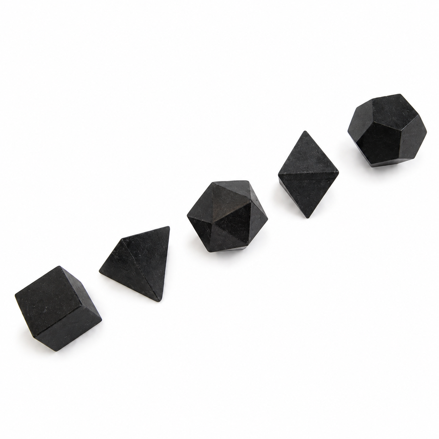 GeoFossils five-piece Black Tourmaline Platonic set with carved cube, tetrahedron, icosahedron, octahedron and dodecahedron on a white background.