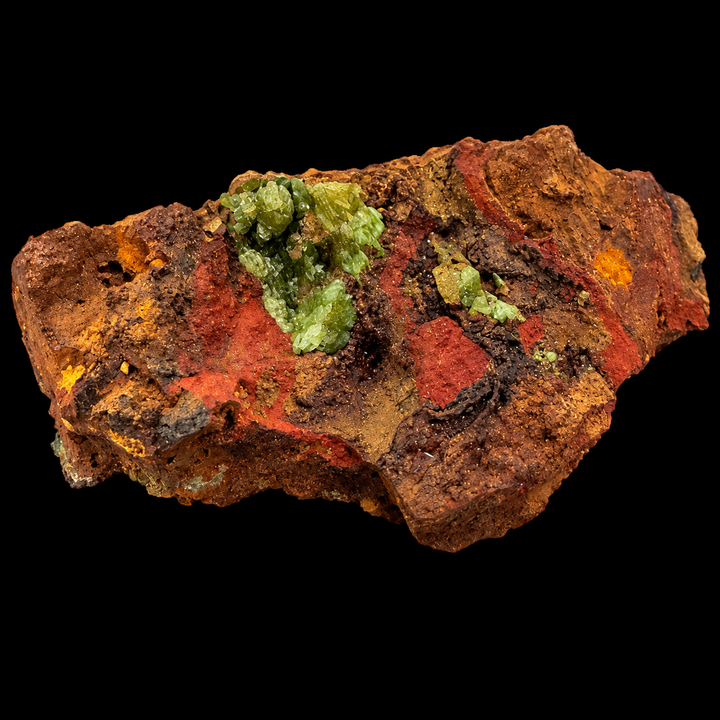 GeoFossils Adamite specimen 192 under Mid Wave UV, showing green fluorescence across scattered crystal clusters on the elongated matrix.