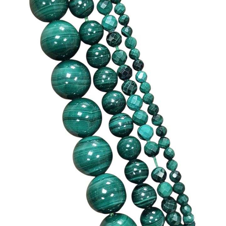 Malachite round beads held in a hand for scale