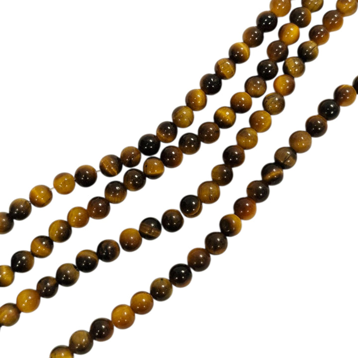 Gold Tigers Eye round beads on a white background