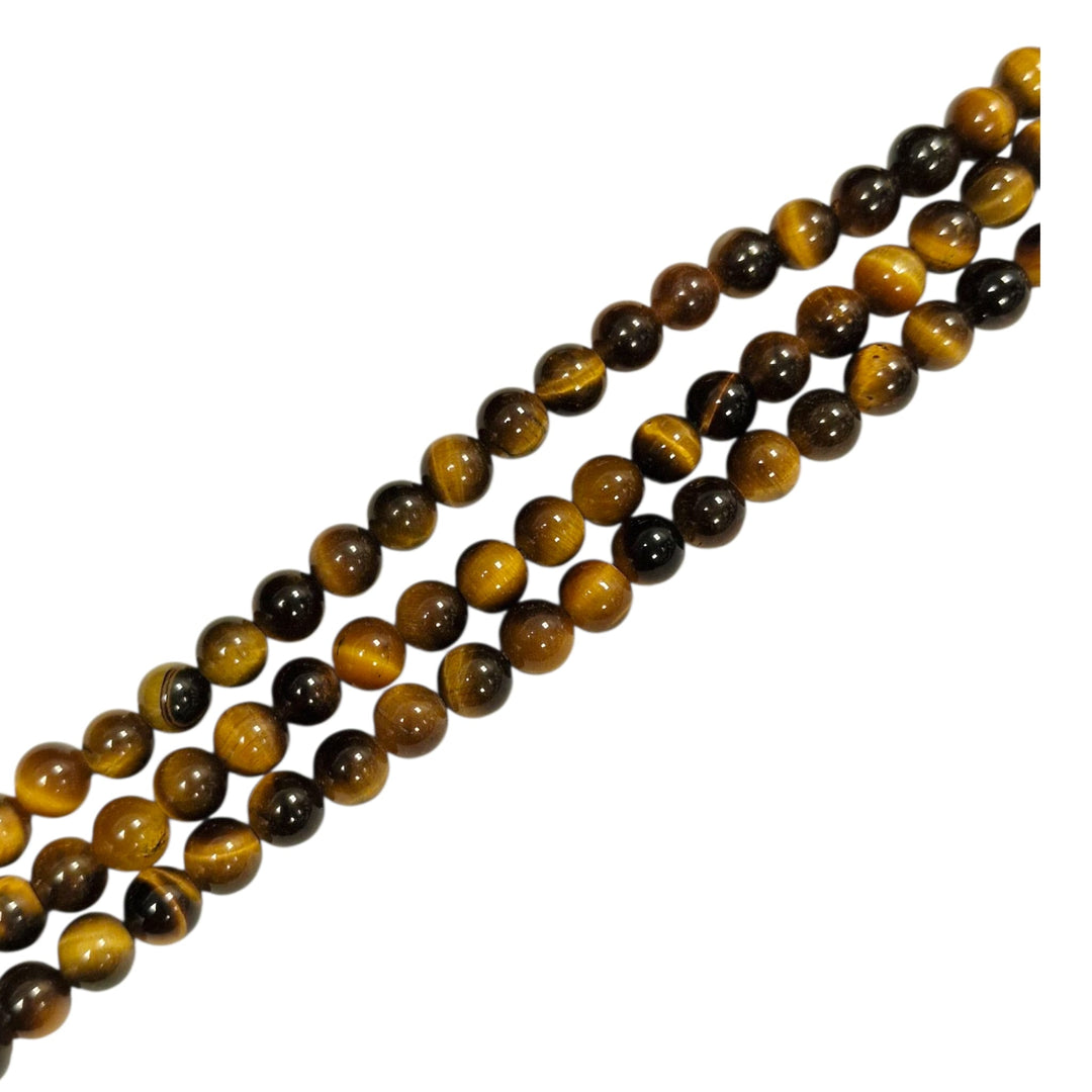 Gold Tigers Eye round beads held in hand for scale