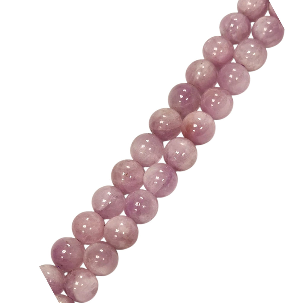 Kunzite round beads held in a hand for scale
