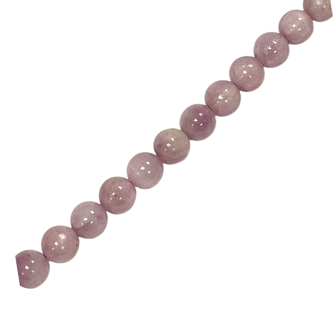 Kunzite round beads on a white background