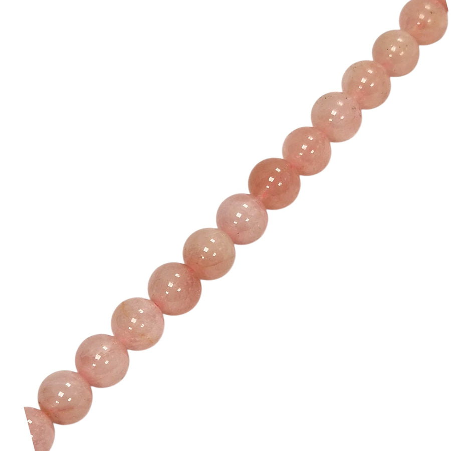 Morganite round beads held in a hand for scale