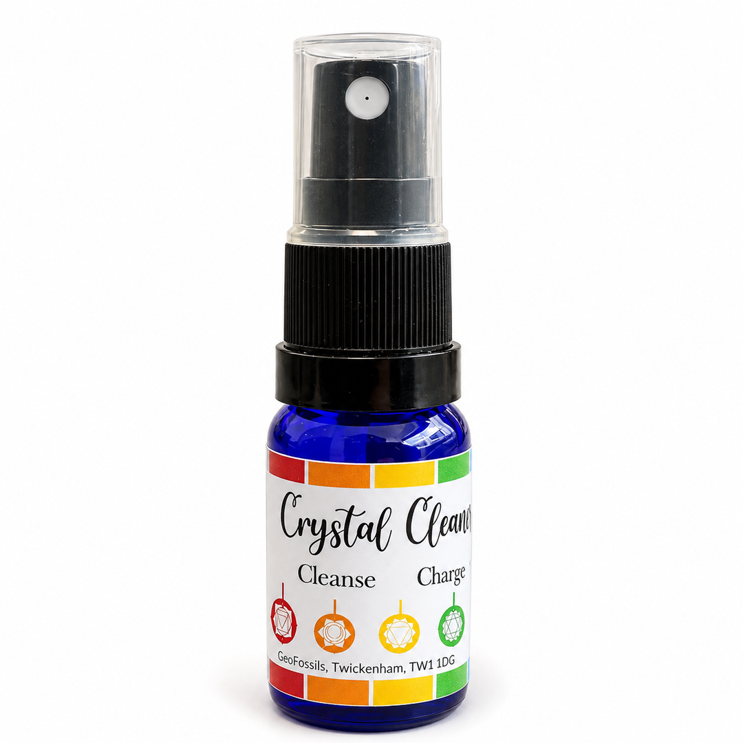 GeoFossils crystal cleansing spray in a cobalt blue bottle with black pump and chakra-style label on a white background.