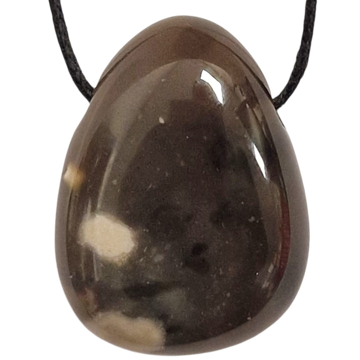 Polished Black Flint tumble stone pendant with dark charcoal tones and subtle natural banding, shown on a black cotton cord.
