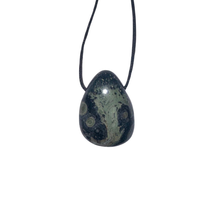 GeoFossils Nebula Stone Drilled Tumble Stone – dark stone with green swirling orbs and horizontal drill hole for deep healing and spiritual transformation