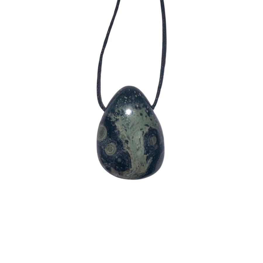 GeoFossils Nebula Stone Drilled Tumble Stone – dark stone with green swirling orbs and horizontal drill hole for deep healing and spiritual transformation