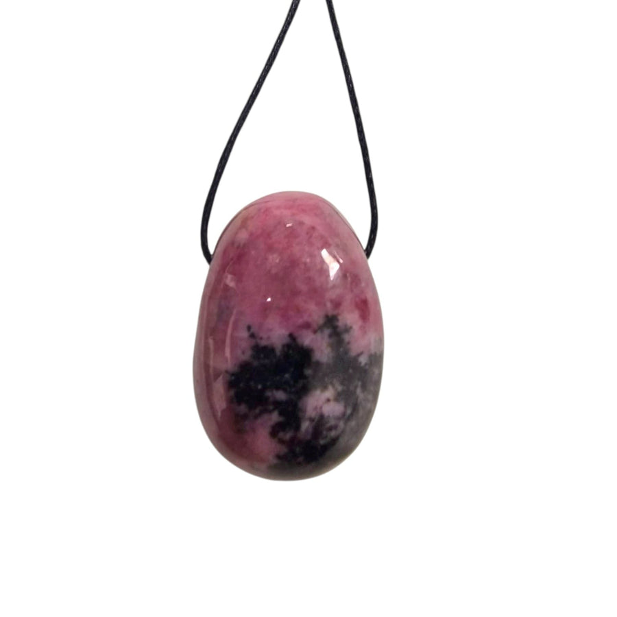 Raspberry pink and black Rhodonite drilled tumble stone pendant on a black cotton cord, showing natural marbled pattern.