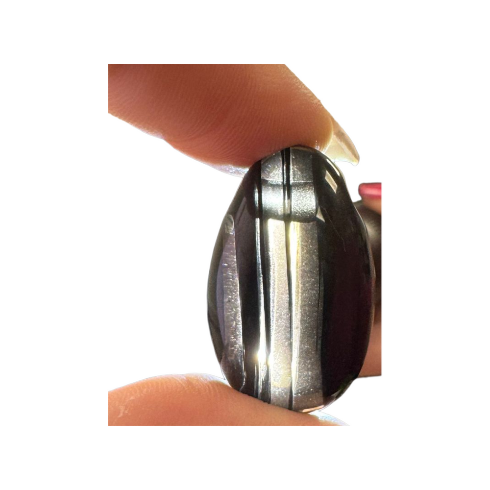 Polished Midnight Lace Obsidian stone with dramatic natural banding and a side drill hole. Known for its shielding and grounding properties, this volcanic glass helps dispel negativity and promote emotional clarity.