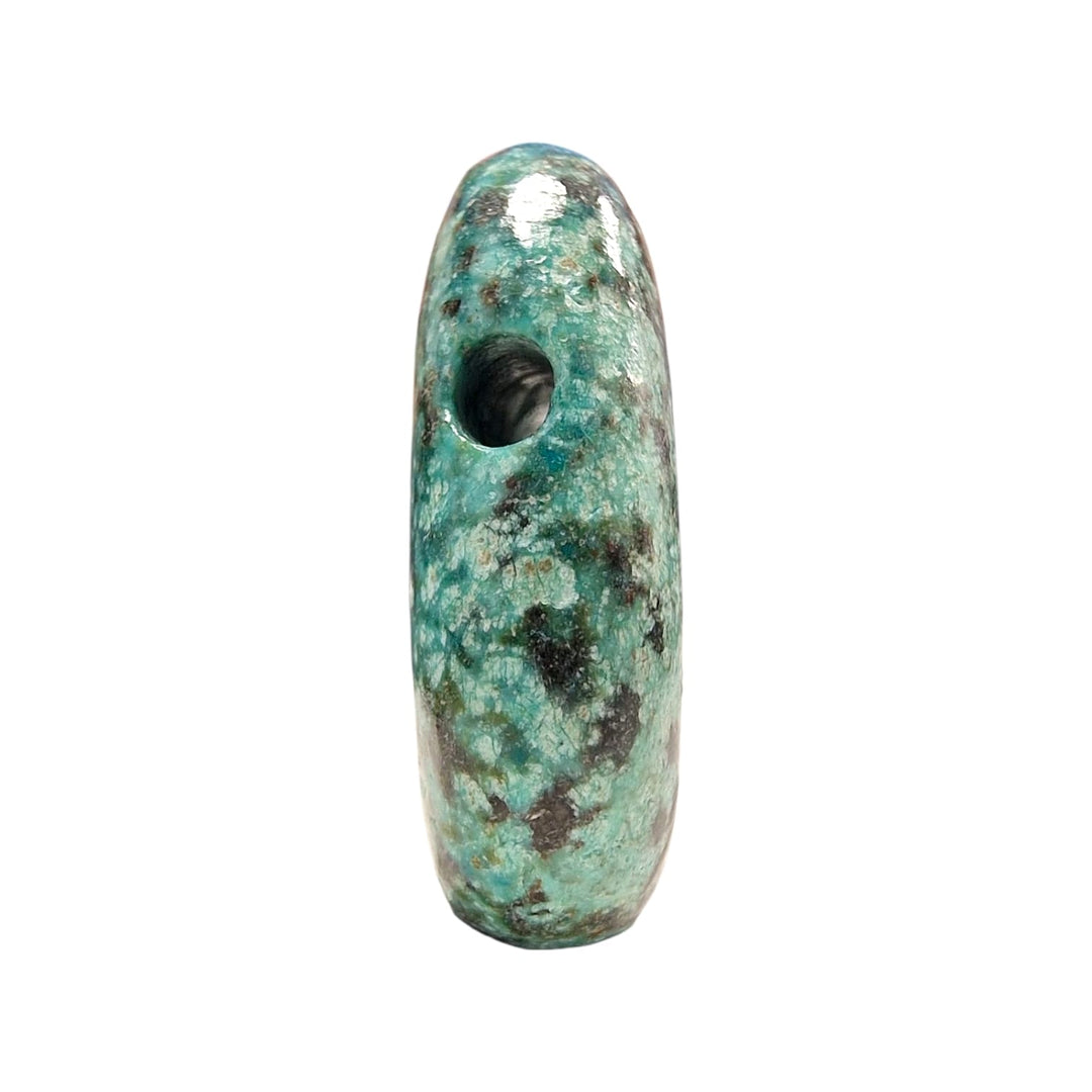 Side profile view of a drilled African Turquoise stone, highlighting the precision of the drill hole and the variegated green and black matrix.
