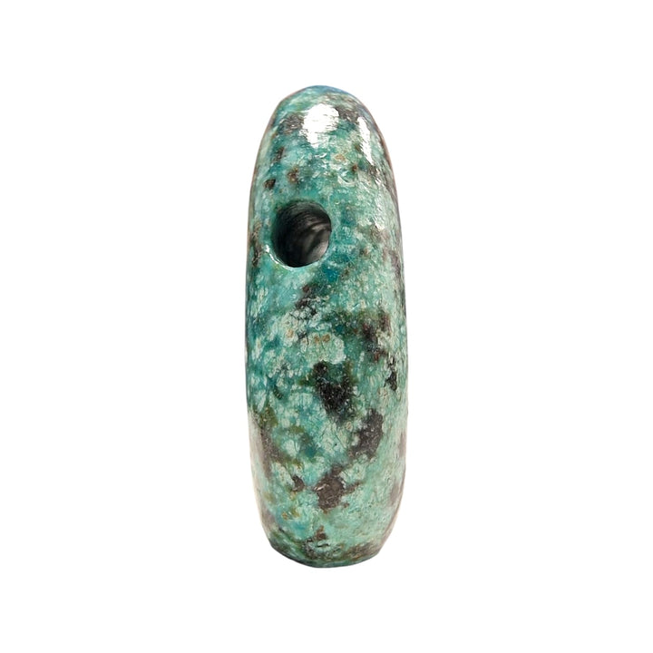 Side profile view of a drilled African Turquoise stone, highlighting the precision of the drill hole and the variegated green and black matrix.