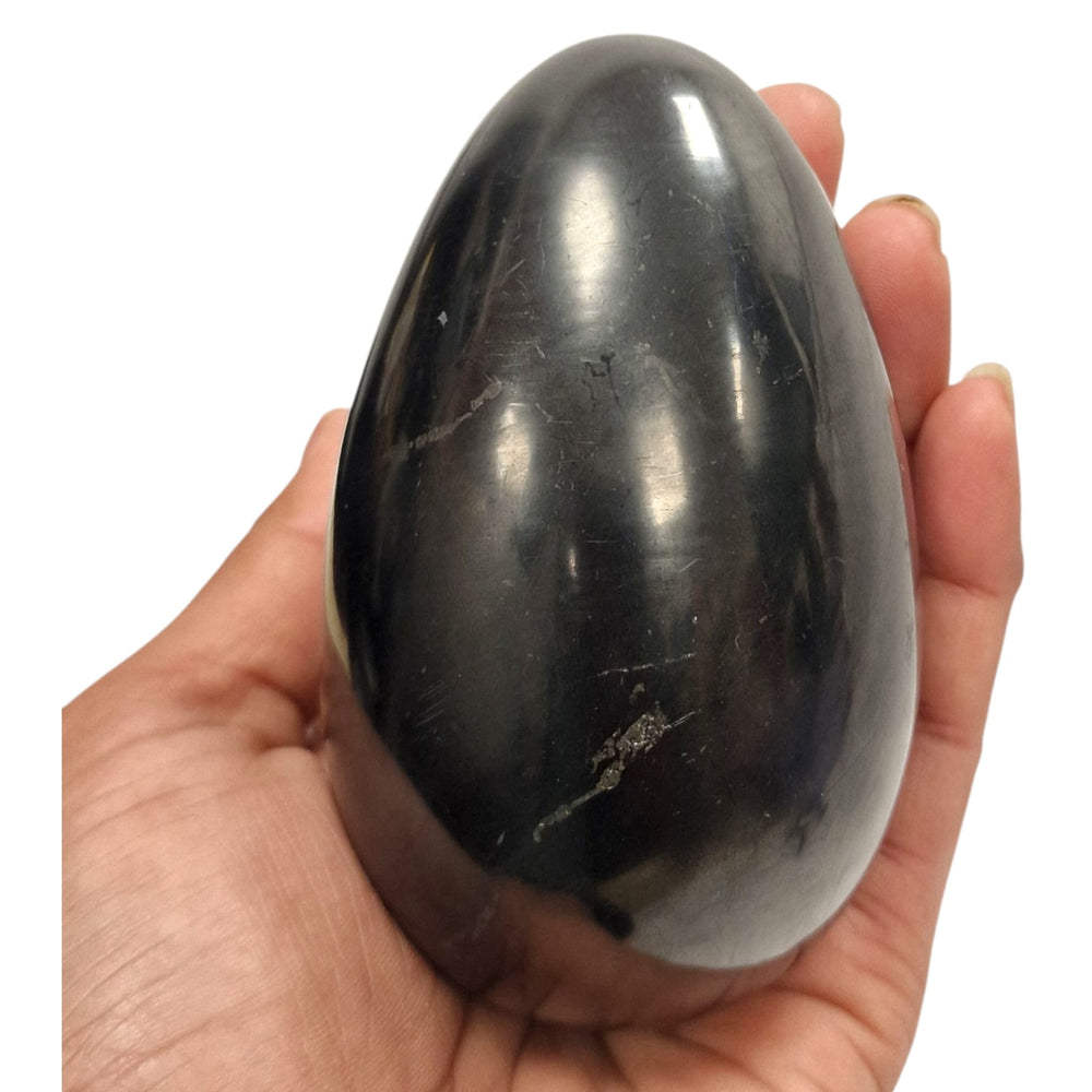 100mm polished Shungite egg on hand, grounding crystal for EMF protection and energy harmonisation