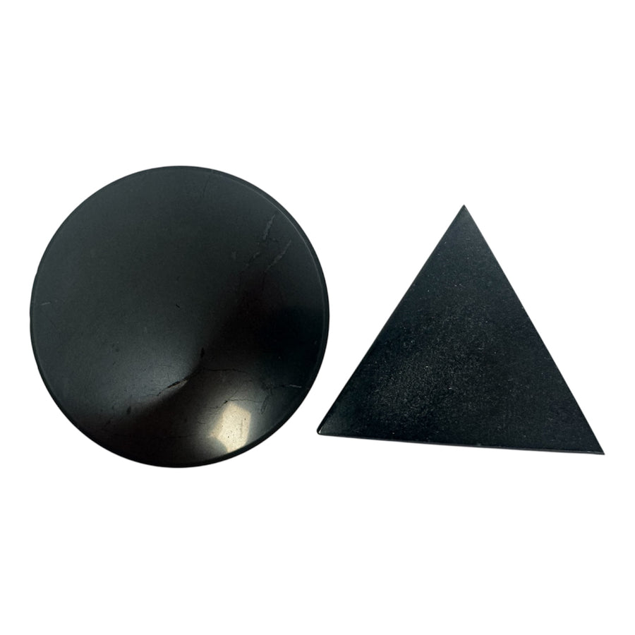 Round polished shungite stone and triangular shungite crystal for energy protection and healing, displayed on a white background.