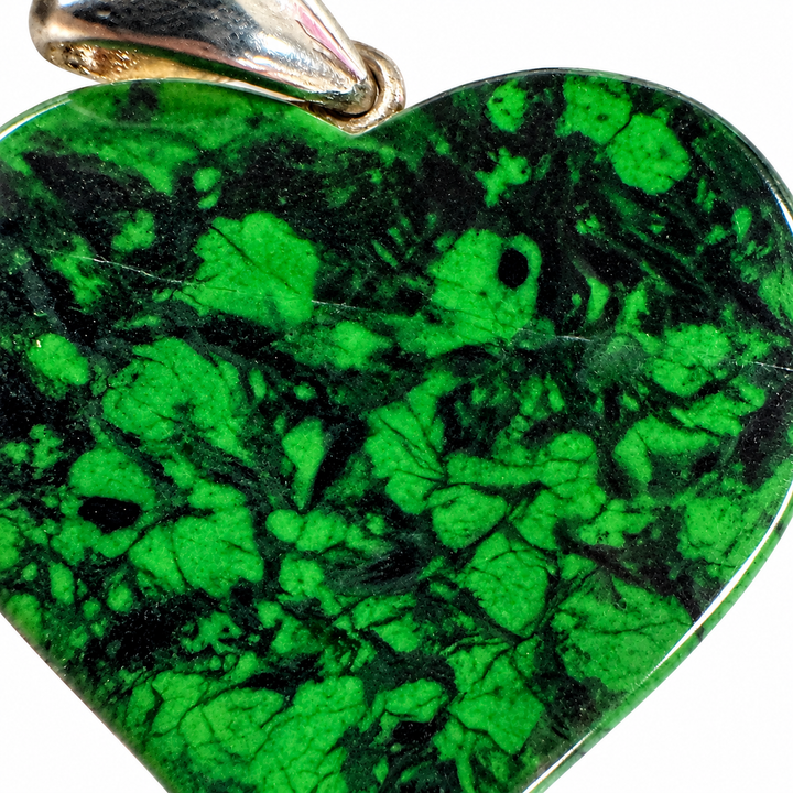 GeoFossils close-up of the Maw Sit Sit heart pendant, highlighting intricate emerald-green and black mottled patterns, natural mineral textures and polished surface.