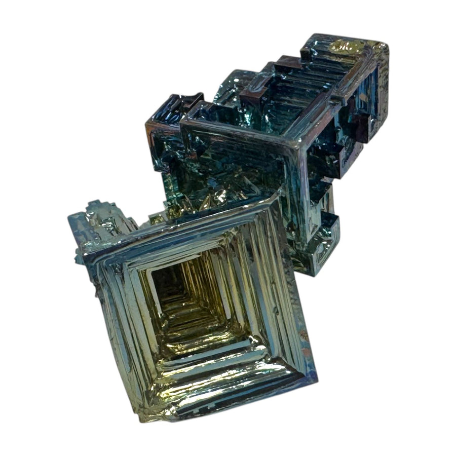 Large Bismuth mineral specimen in hand to show size and detail, showing purple, green, and gold hues.