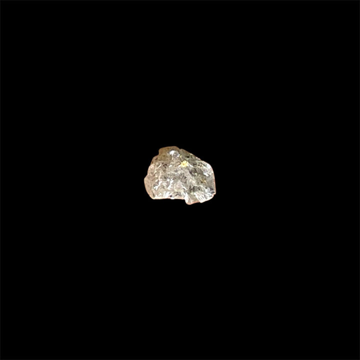 Sparkling UV-reactive gemstone resembling diamond in specimen form