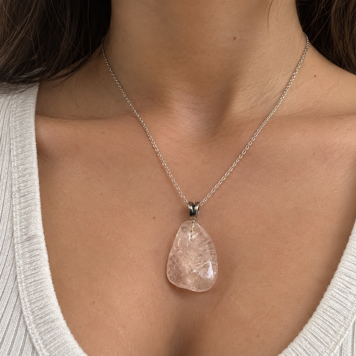 GeoFossils Morganite Tumblestone Pendant worn on a delicate silver chain by a model in an ivory top, showcasing the natural blush-pink gemstone and its appearance when worn.