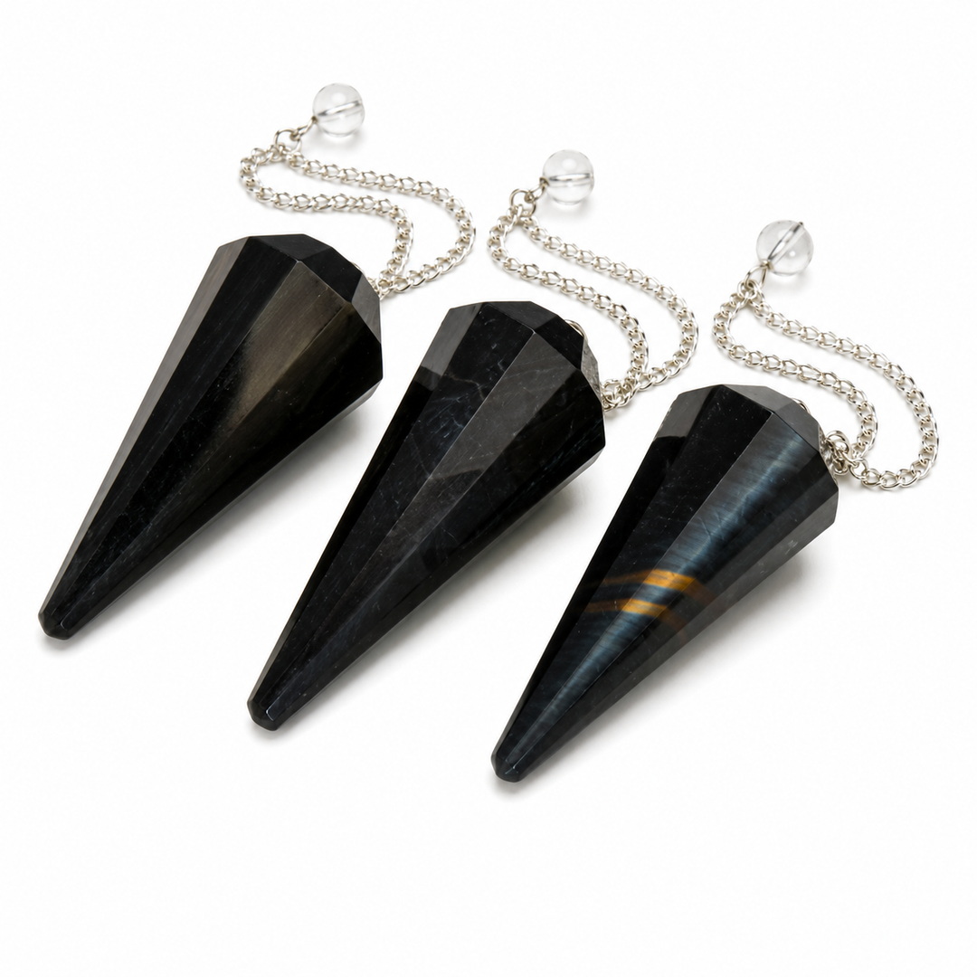 Three faceted black crystal cone pendants with silver chains and clear glass spheres, arranged diagonally on a white background.