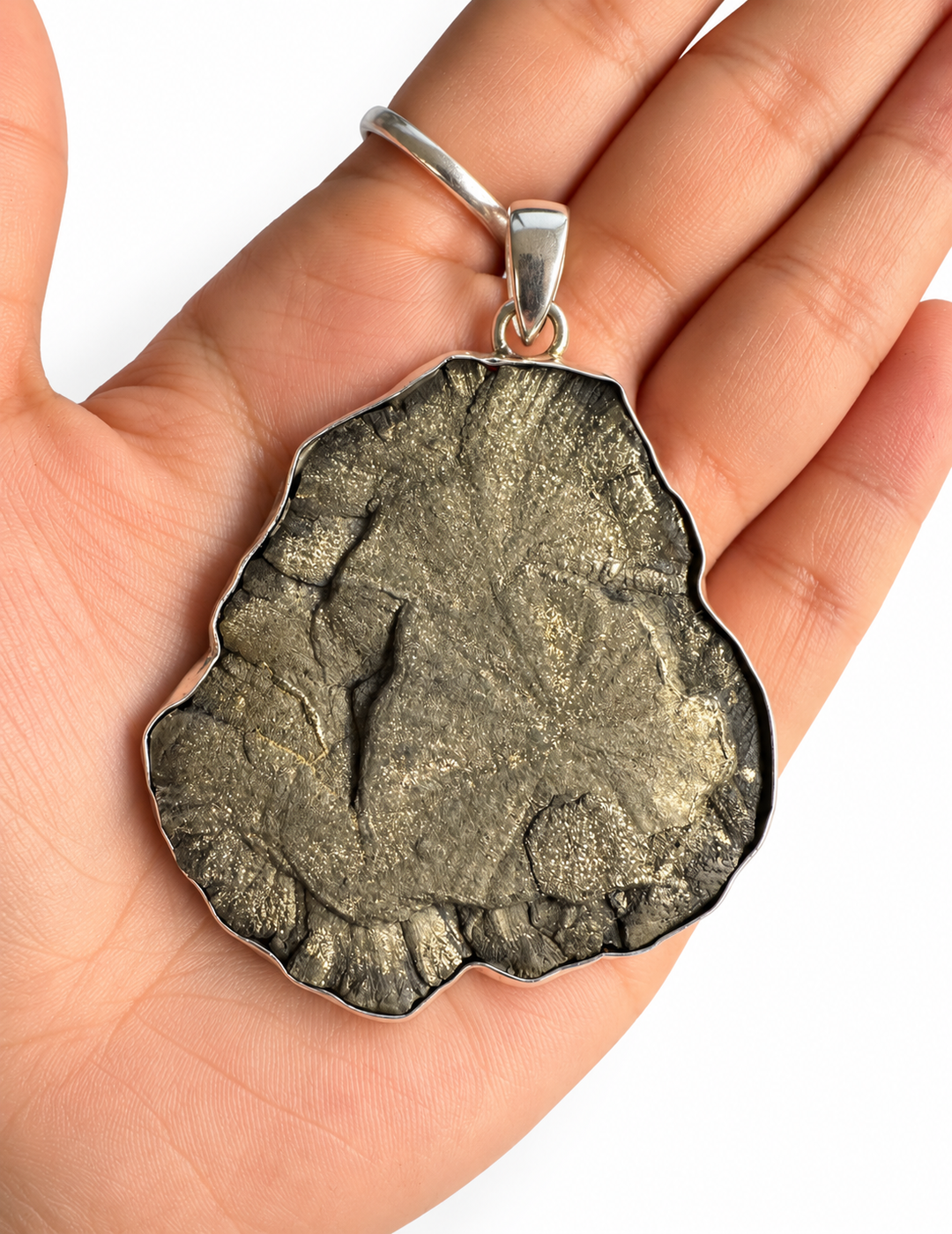 Large natural Pyrite Sun pendant resting in a hand, showing its statement size, organic shape and sterling silver setting.