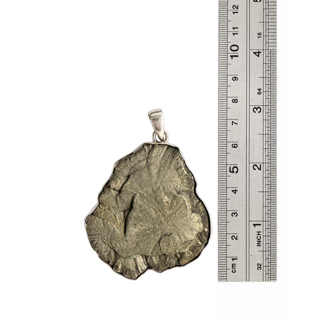 Natural Pyrite Sun pendant beside a centimetre ruler showing its approximate 7 cm overall length including the sterling silver bail.