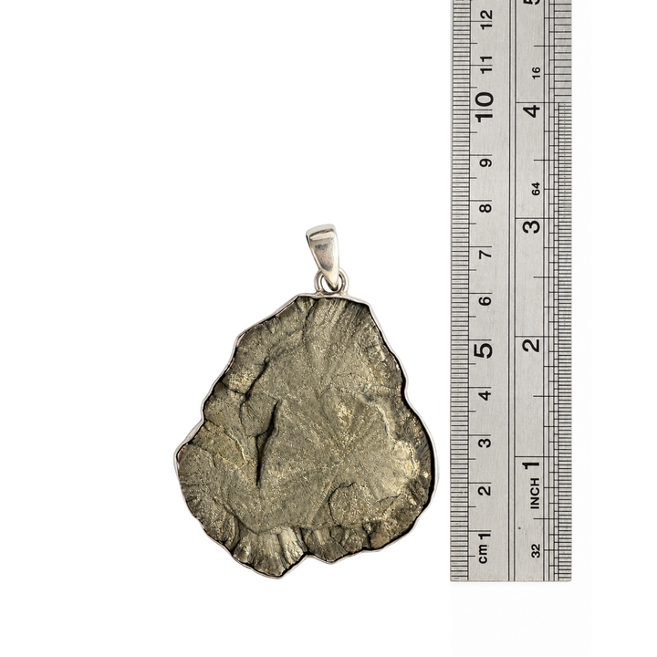 Natural Pyrite Sun pendant beside a centimetre ruler showing its approximate 7 cm overall length including the sterling silver bail.