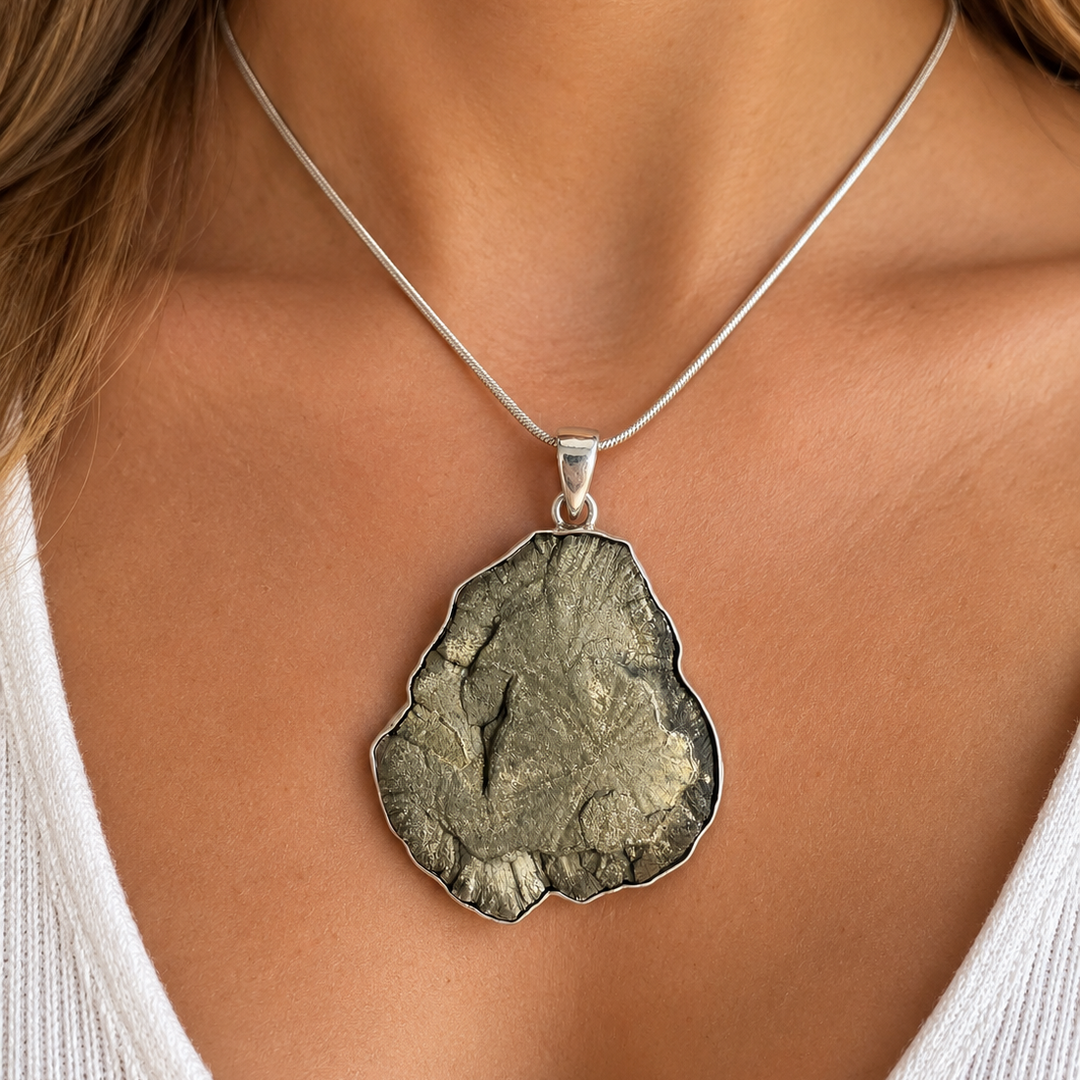 Natural Pyrite Sun statement pendant worn on a model, showcasing its large organic shape and metallic mineral texture.