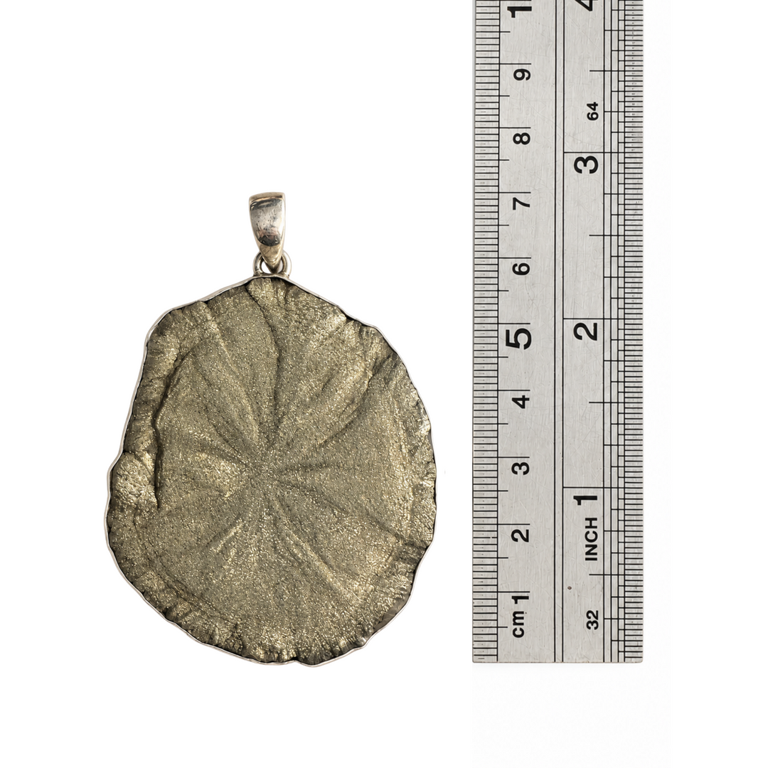 Natural Pyrite Sun pendant photographed beside a centimetre ruler to show its actual dimensions, including the sterling silver bail.