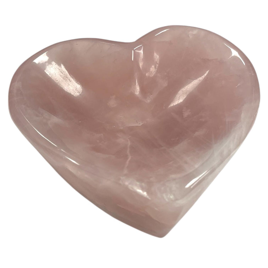 Heart-shaped rose quartz bowl used for crystals, jewelry, or rituals – soft pink crystal with natural patterning