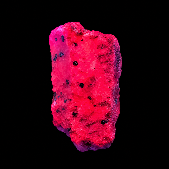 GeoFossils Ruby mineral specimen 206 displaying bright red-pink fluorescence under UV light against a black background.