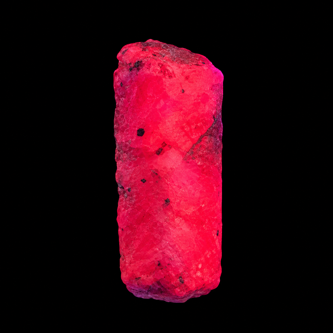 GeoFossils Ruby mineral specimen 208 displaying bright red-pink fluorescence under UV light against a black background.