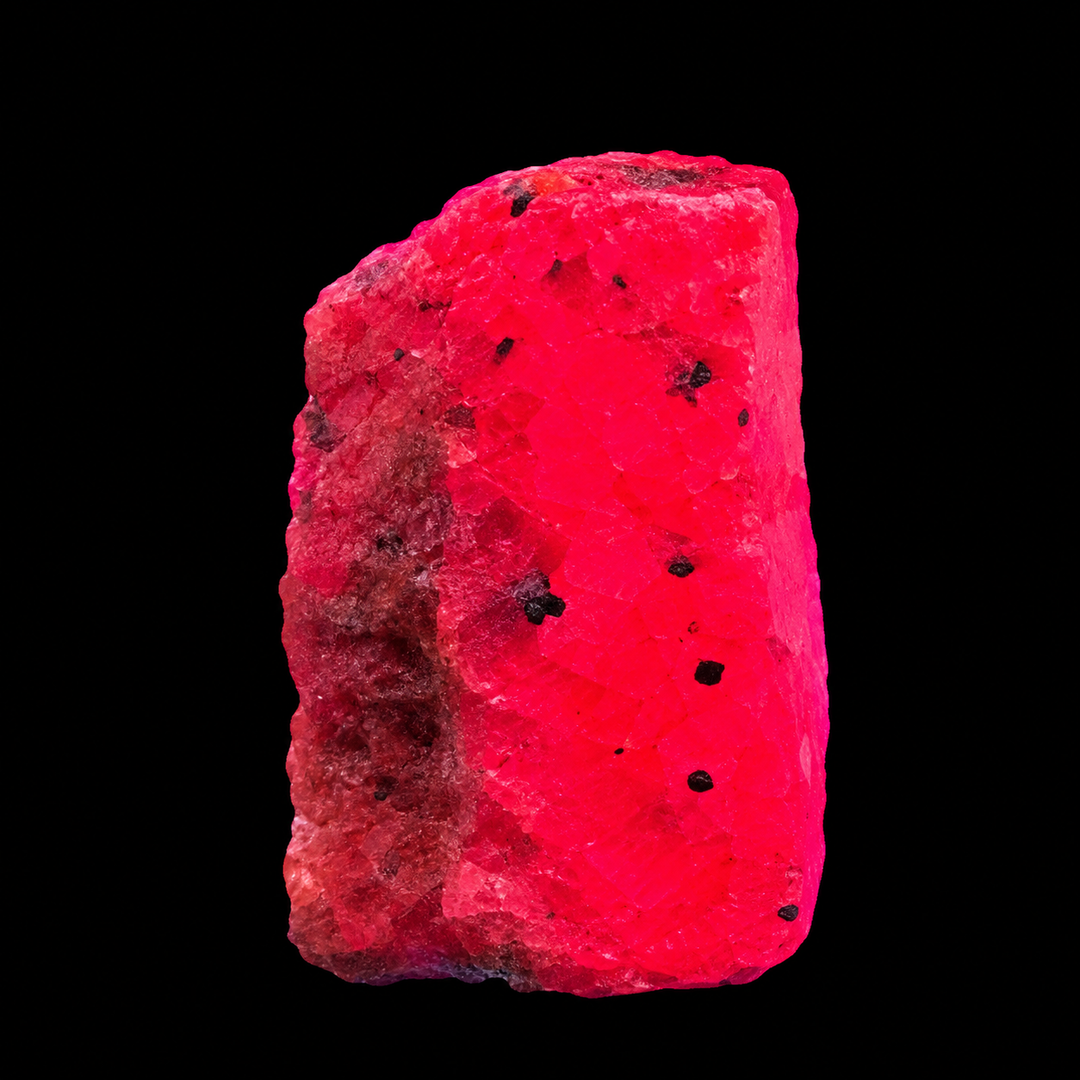 GeoFossils Ruby mineral specimen 210 displaying bright red-pink fluorescence under UV light against a black background.