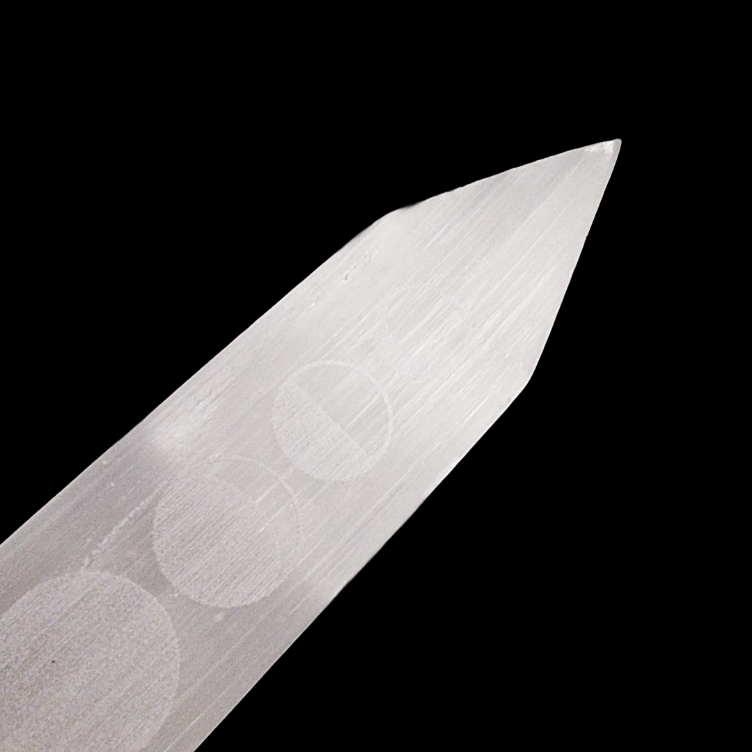Tip view of Selenite Moon Phase Blade – Engraved Polished Wand. Black Background