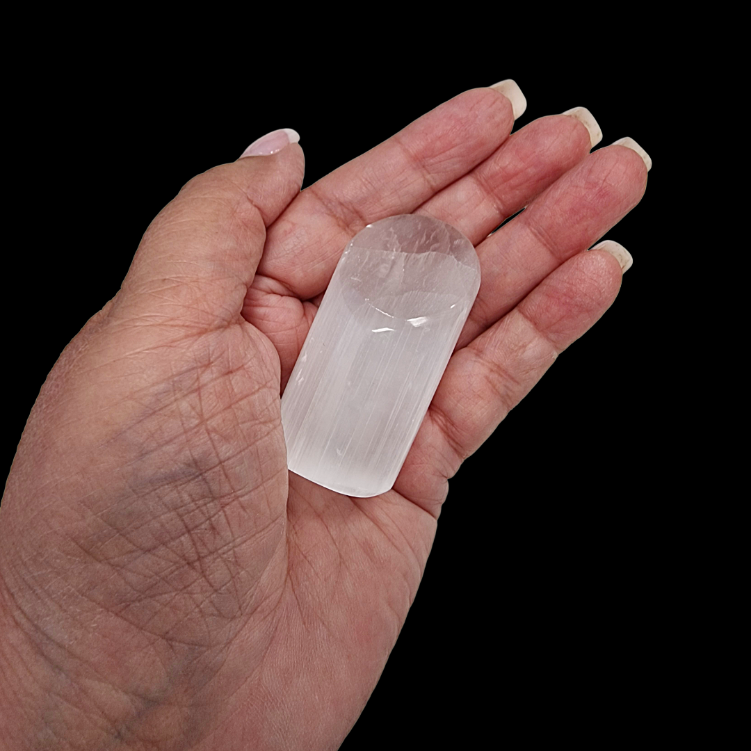 Selenite Lipstick Tower 6 cm natural finish shown in hand for scale.