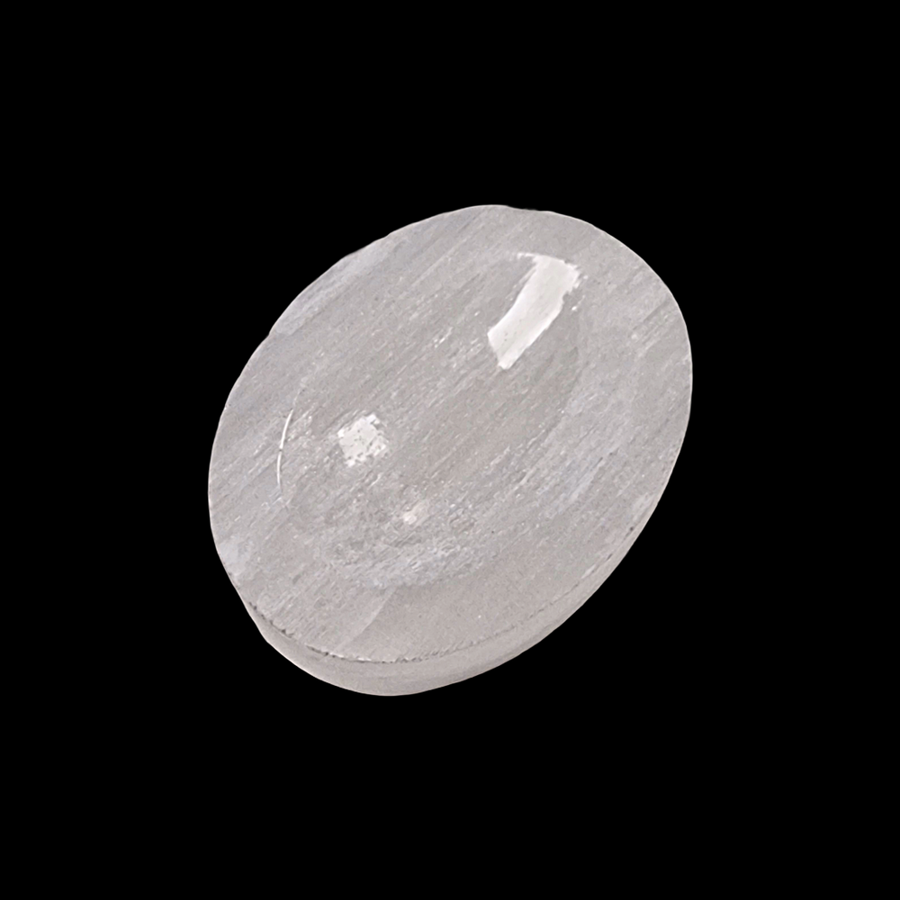 Selenite Worry Stone crystal shown on black background.