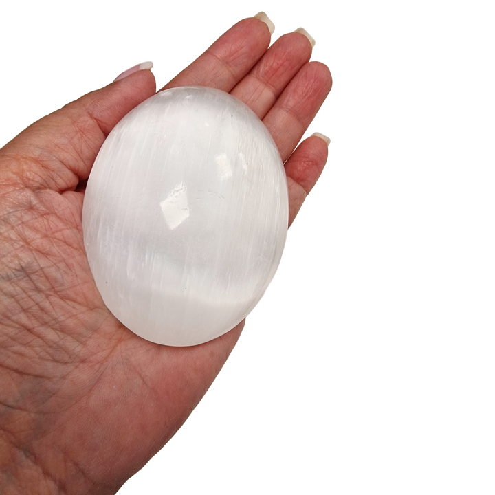 Selenite Palm Stone 90 mm shown on hand for scale.