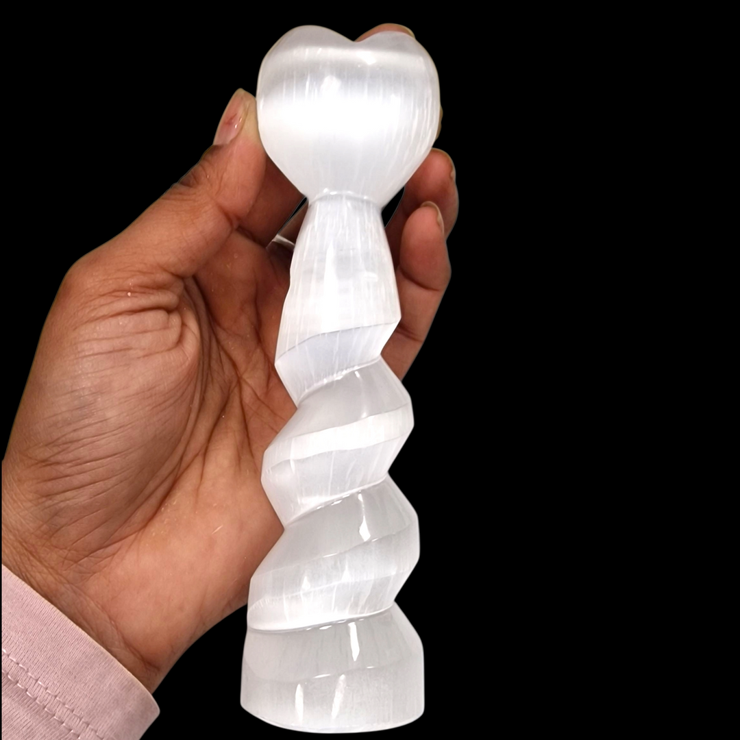 Selenite Spiral Heart Tower 15 cm shown on hand for scale on a black background