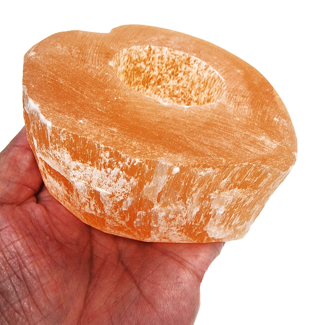 Peach Selenite Heart Tea Light Holder shown in hand for scale.