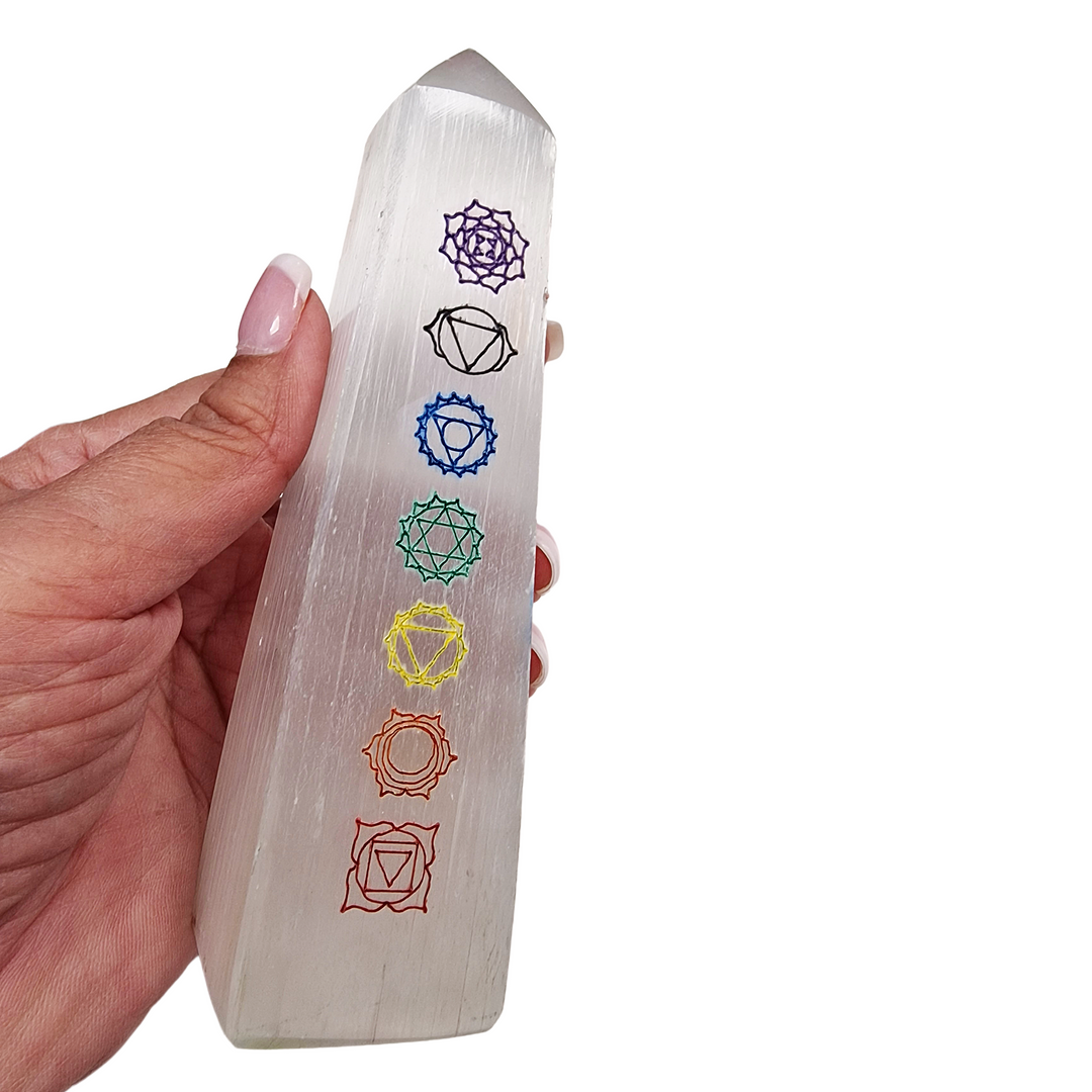 Selenite Chakra Tower 12cm polished with 7 chakra symbols, shown in hand for scale.