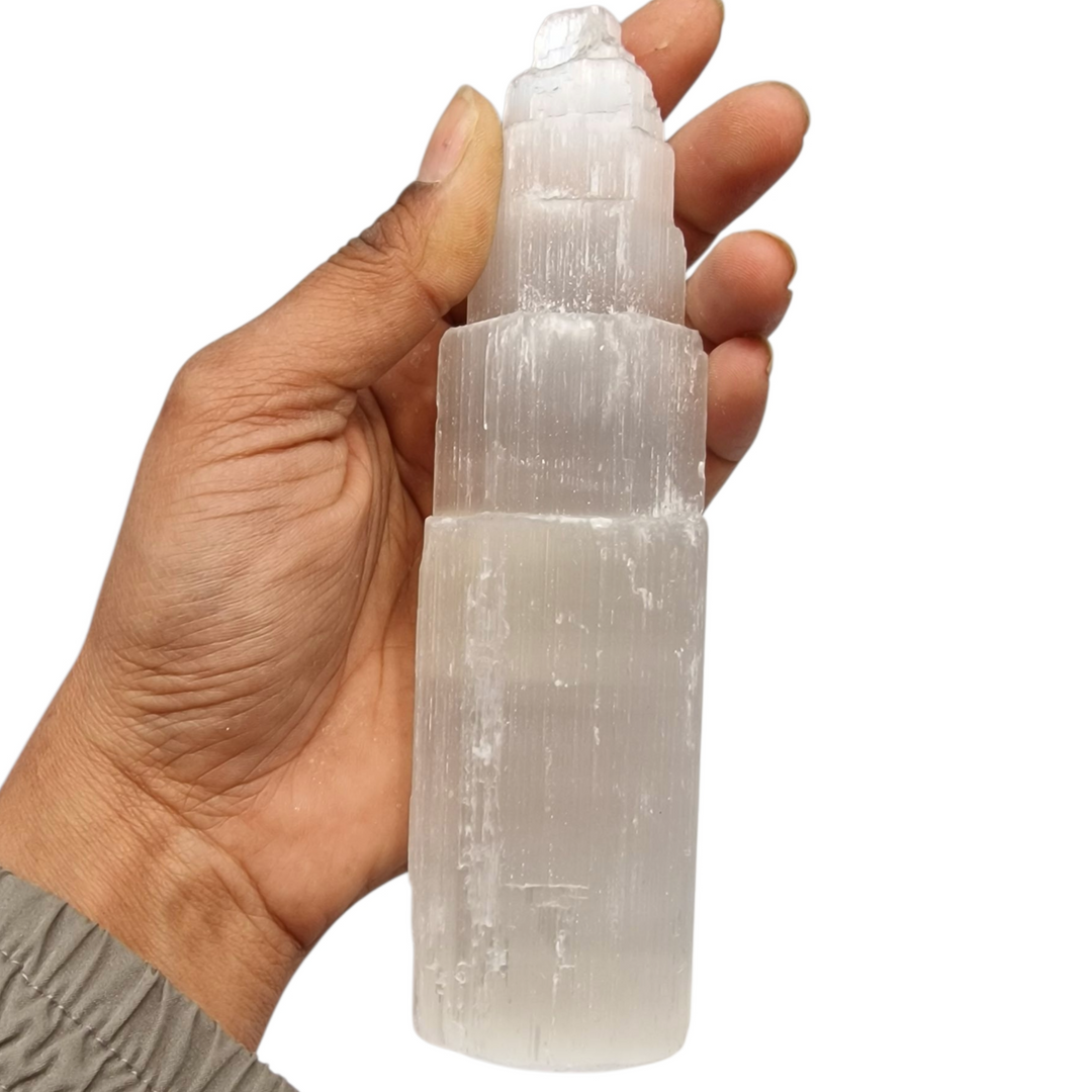 Selenite Tower 15 cm ultra white iceberg finish shown on hand for scale.