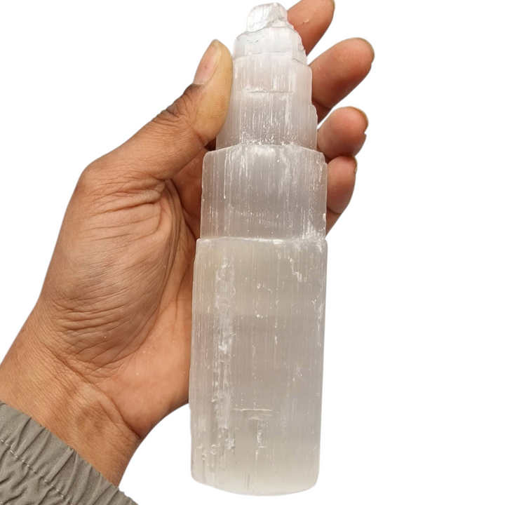 Selenite Tower 15 cm ultra white iceberg finish shown on hand for scale.
