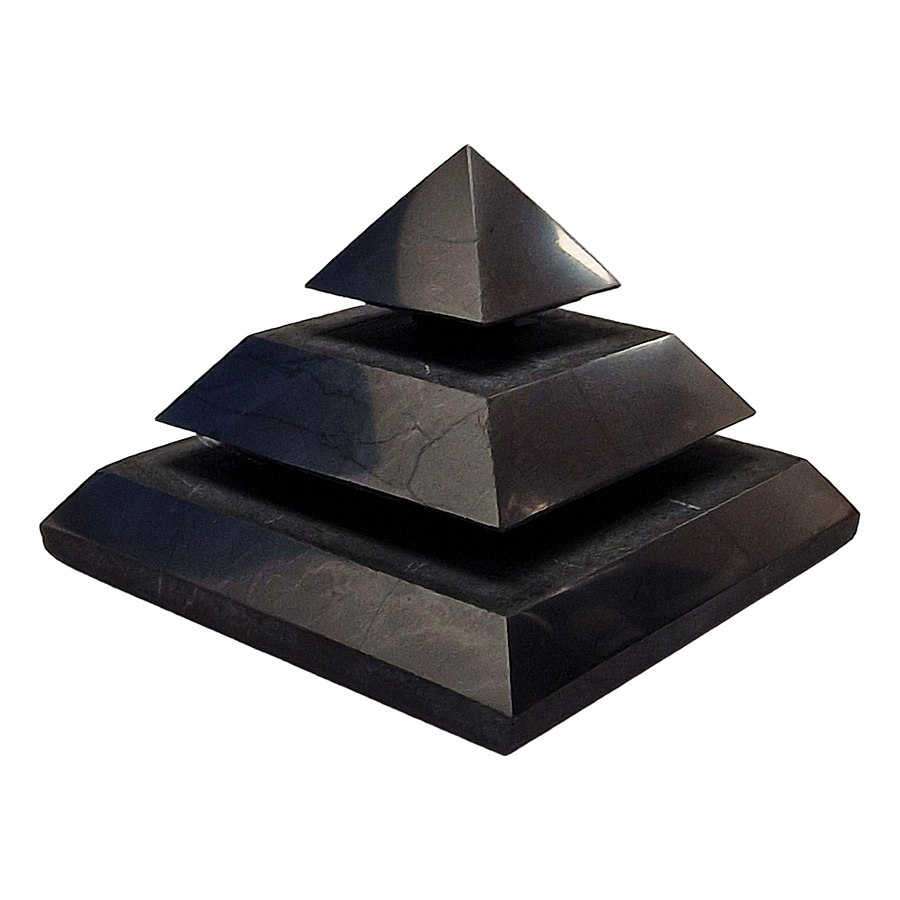 Side view of Saqqara Shungite Pyramid 40mm on white background, shungite crystal for grounding and EMF shielding