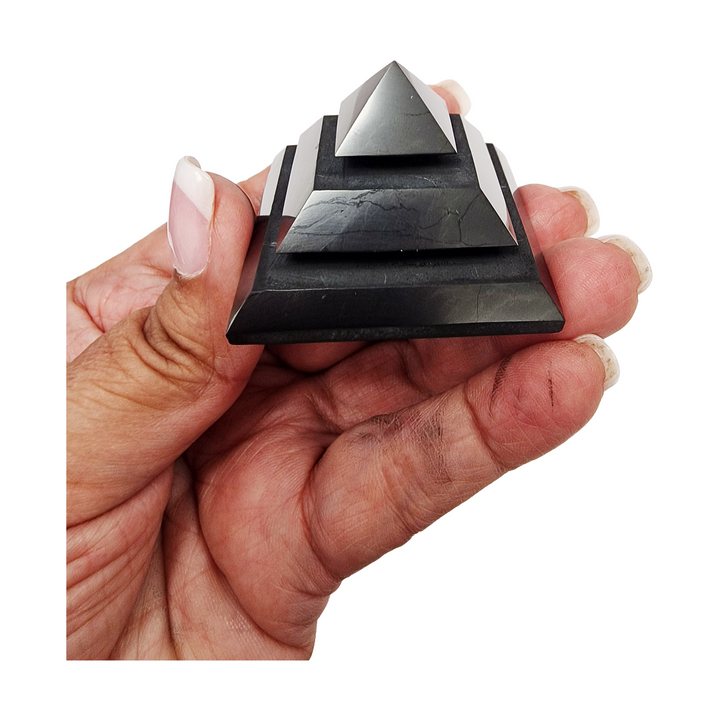 Saqqara Shungite Pyramid 40mm on hand for size reference, grounding and EMF protection crystal