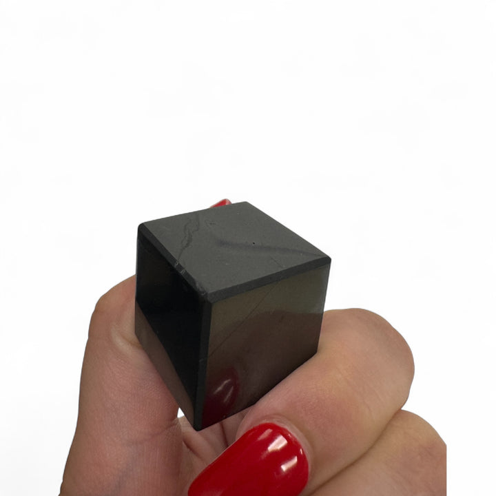 Small 20mm Shungite cube held in hand – authentic healing stone for stress relief, grounding, and aura cleansing.