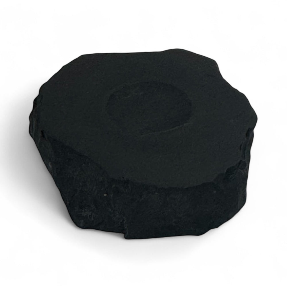 Small shungite base with round carved indent, used to hold crystal spheres for energy balancing and EMF protection.