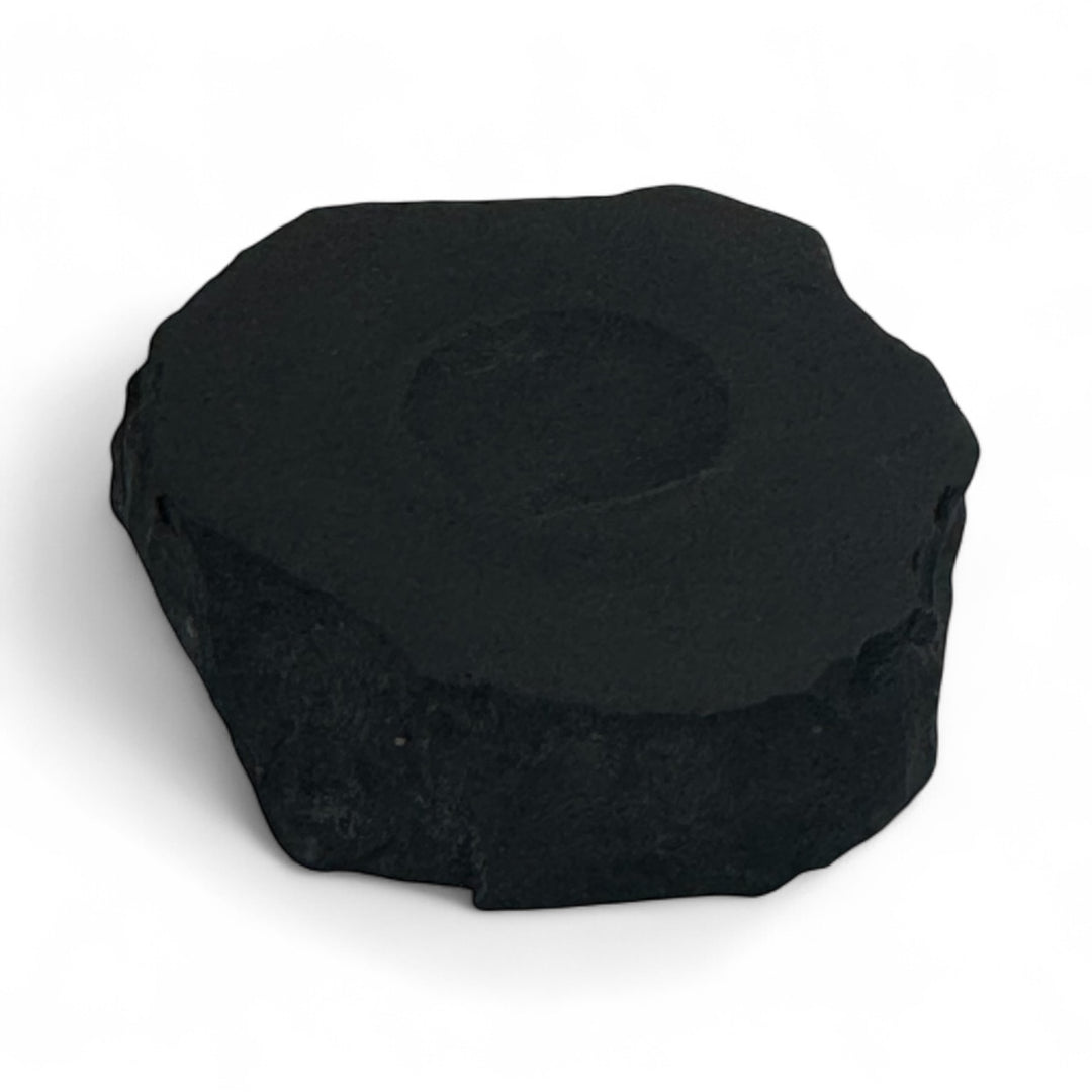 Small shungite base with round carved indent, used to hold crystal spheres for energy balancing and EMF protection.