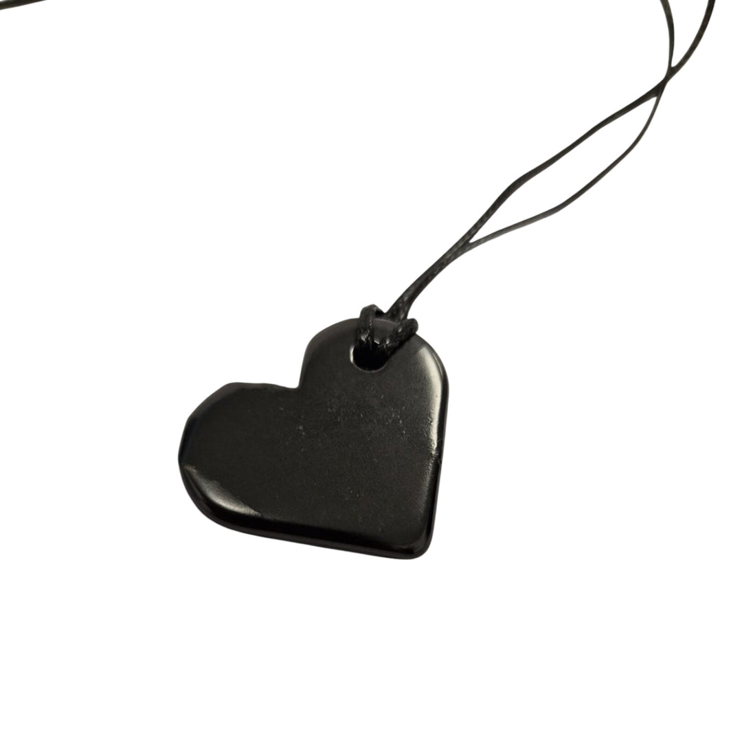 Close-up of 30mm heart-shaped Shungite pendant showing smooth finish and black cotton cord