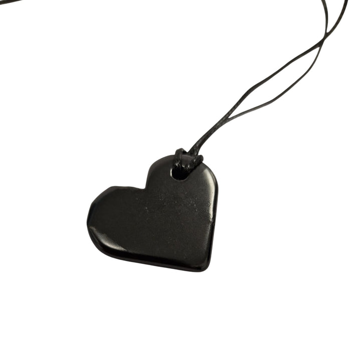 Close-up of 30mm heart-shaped Shungite pendant showing smooth finish and black cotton cord