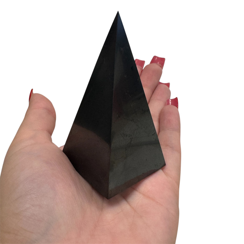 Shungite Nubian Pyramid held in hand – grounding crystal for meditation, healing, and spiritual protection